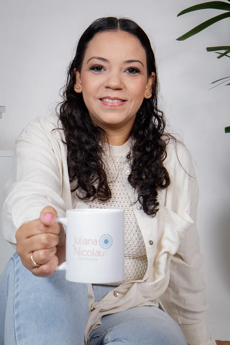 Juliana Nicolau segurando uma caneca com sua marca